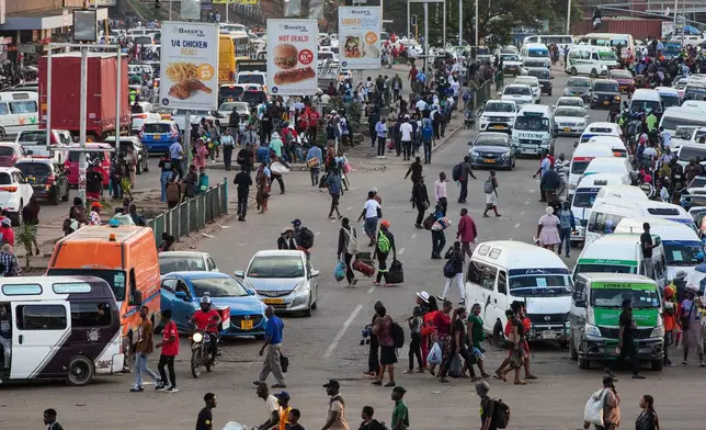 An overview of commuters at a minibus taxi area during rush hour in downtown Harare, Zimbabwe, Tuesday, Dec. 16, 2025.(AP Photo/Aaron Ufumeli)