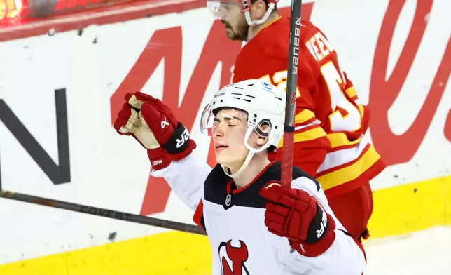 New Jersey Devils' Simon Nemec, bottom, celebrates after his overtime goal against the Calgary Flames during NHL hockey game action in Calgary, Alberta, Monday, Jan. 19, 2026. (Larry MacDougal/The Canadian Press via AP)