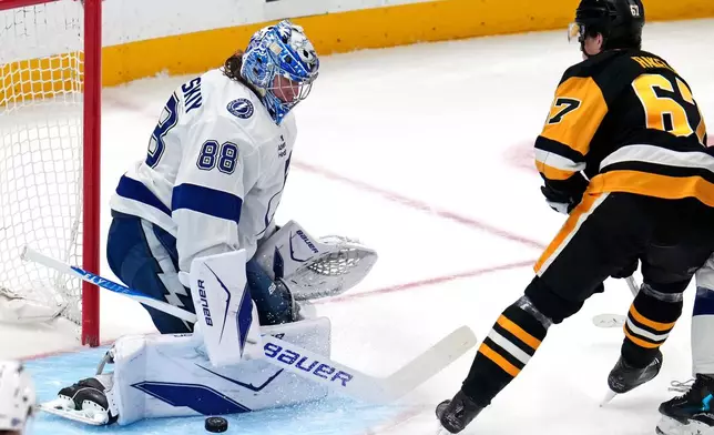 Tampa Bay Lightning goaltender Andrei Vasilevskiy (88) blocks a shot by Pittsburgh Penguins' Rickard Rakell during the first period of an NHL hockey game in Pittsburgh, Tuesday, Jan. 13, 2026. (AP Photo/Gene J. Puskar)
