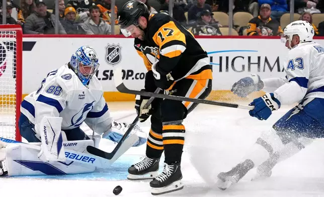 Pittsburgh Penguins' Bryan Rust (17) can't get his stick on the puck in front of Tampa Bay Lightning goaltender Andrei Vasilevskiy (88) with Darren Raddysh (43) defending during the second period of an NHL hockey game in Pittsburgh, Tuesday, Jan. 13, 2026. (AP Photo/Gene J. Puskar)