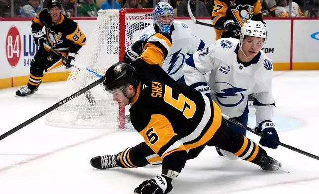 Pittsburgh Penguins' Ryan Shea (5) collides with Tampa Bay Lightning's Yanni Gourde (37) in front of Andrei Vasilevskiy (88) during the second period of an NHL hockey game in Pittsburgh, Tuesday, Jan. 13, 2026. (AP Photo/Gene J. Puskar)
