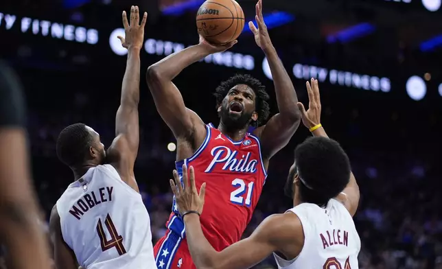 Philadelphia 76ers' Joel Embiid (21) goes up for a shot against Cleveland Cavaliers' Evan Mobley (4) and Jarrett Allen (31) during the first half of an NBA basketball game Friday, Jan. 16, 2026, in Philadelphia. (AP Photo/Matt Slocum)