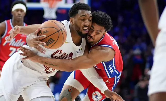 Cleveland Cavaliers' Donovan Mitchell, left, and Philadelphia 76ers' Quentin Grimes collide during the first half of an NBA basketball game Friday, Jan. 16, 2026, in Philadelphia. (AP Photo/Matt Slocum)