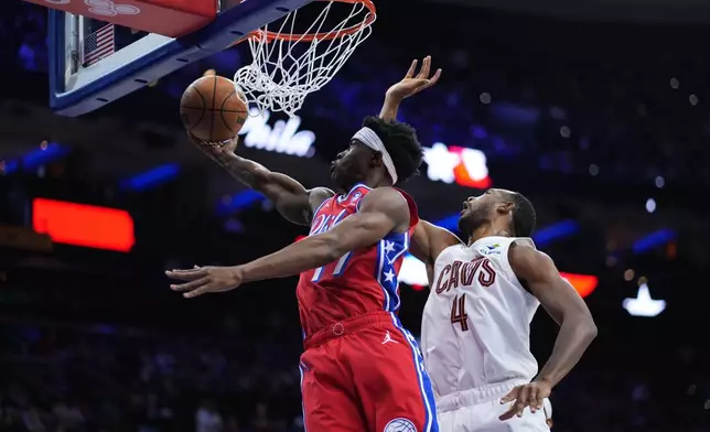 Philadelphia 76ers' VJ Edgecombe, left, goes up for a shot past Cleveland Cavaliers' Evan Mobley during the first half of an NBA basketball game Friday, Jan. 16, 2026, in Philadelphia. (AP Photo/Matt Slocum)