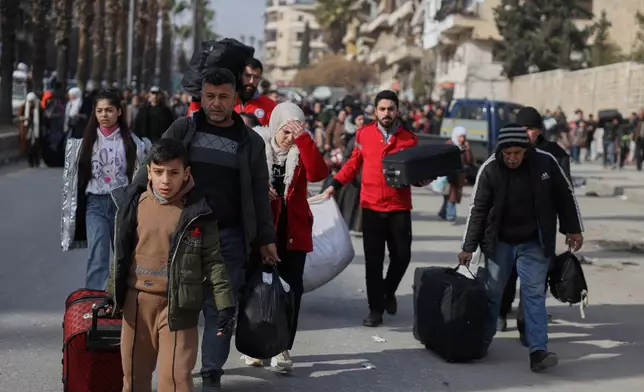 Residents flee the Sheikh Maqsoud and Achrafieh neighborhoods after clashes broke out on Tuesday between Syrian government forces and Kurdish fighters in a contested area of the northern city of Aleppo, Syria, Wednesday, Jan. 7, 2026. (AP Photo/Omar Albam)