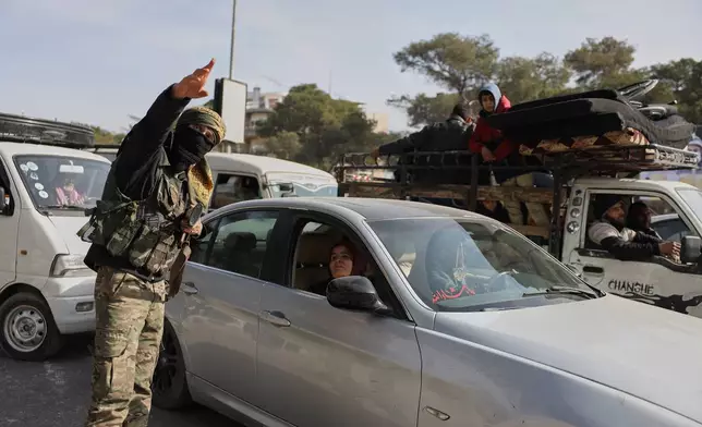 A Syrian government soldier directs residents who are fleeing from Sheikh Maqsoud and Achrafieh neighborhoods after clashes broke out on Tuesday between Syrian government forces and Kurdish fighters in a contested area of the northern city of Aleppo, Syria, Wednesday, Jan. 7, 2026. (AP Photo/Omar Albam)
