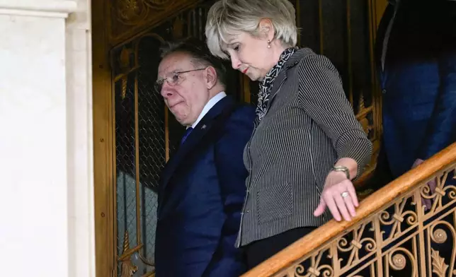 Quebec Premier Francois Legault and his wife, Isabelle Brais, walk to a news conference to announce his resignation in Quebec City, on Wednesday, Jan. 14, 2026. (Jacques Boissinot/The Canadian Press via AP)