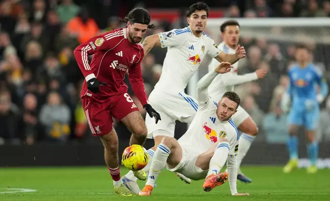 Liverpool's Dominik Szoboszlai, left, and Leeds' Gabriel Gudmundsson challenge for the ball during the English Premier League soccer match between Liverpool and Leeds United in Liverpool, England, Thursday, Jan. 1, 2026. (AP Photo/Jon Super)