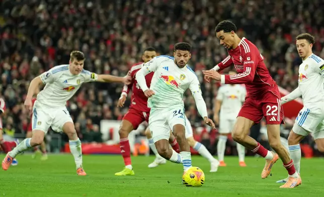 Liverpool's Hugo Ekitike, right, and Leeds' James Justin, center, challenge for the ball during the English Premier League soccer match between Liverpool and Leeds United in Liverpool, England, Thursday, Jan. 1, 2026. (AP Photo/Jon Super)
