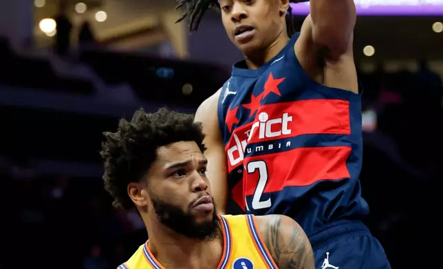 Charlotte Hornets forward Miles Bridges, left, passes against Washington Wizards guard Tre Johnson during the first half of an NBA basketball game in Charlotte, N.C., Saturday, Jan. 24, 2026. (AP Photo/Nell Redmond)