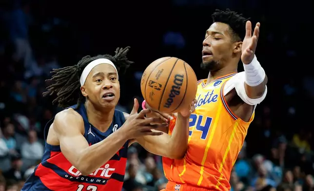 Washington Wizards guard Tre Johnson (12) drives to the basket against Charlotte Hornets forward Brandon Miller during the second half of an NBA basketball game in Charlotte, N.C., Saturday, Jan. 24, 2026. (AP Photo/Nell Redmond)