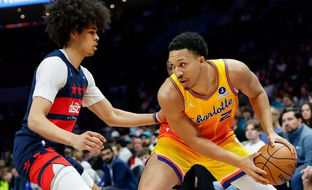 Charlotte Hornets forward Grant Williams (2) looks to drive against Washington Wizards guard Kyshawn George during the first half of an NBA basketball game in Charlotte, N.C., Saturday, Jan. 24, 2026. (AP Photo/Nell Redmond).