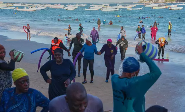 FILE - Participants walk out of the ocean after a group aquatic therapy session in Dakar, Senegal, Saturday, Dec. 13, 2025. (AP Photo/Misper Apawu, File)