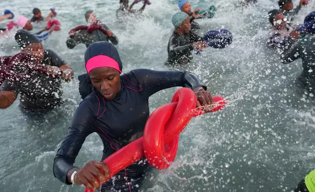 FILE - People take part in a group aquatic therapy session in the ocean in Dakar, Senegal, Saturday, Dec. 13, 2025. (AP Photo/Misper Apawu, File)