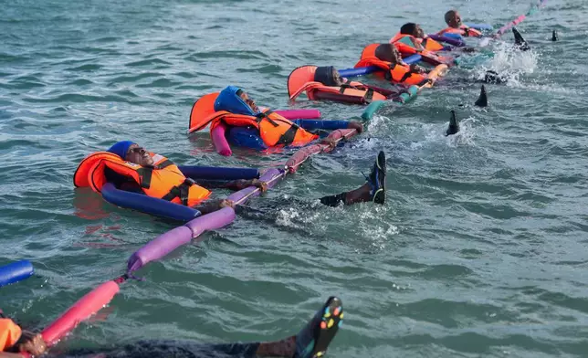 FILE - People with limited mobility issues receiving therapy in the ocean in Dakar, Senegal, Saturday, Dec. 13, 2025. (AP Photo/Misper Apawu, File)