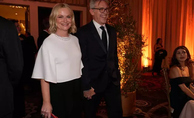 Amy Poehler, left, and Joel Lovell arrive at the 83rd Golden Globes on Sunday, Jan. 11, 2026, at the Beverly Hilton in Beverly Hills, Calif. (AP Photo/Chris Pizzello)