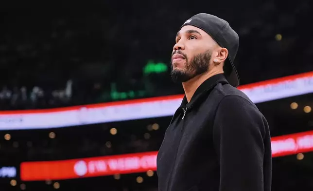 Boston Celtics forward Jayson Tatum, who is out with an injury, stands near the bench during a time out in the first half of an NBA basketball game against the Denver Nuggets, Wednesday, Jan. 7, 2026, in Boston. (AP Photo/Charles Krupa)