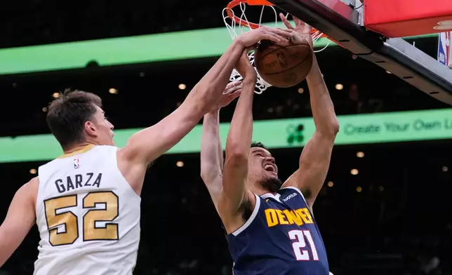 Boston Celtics center Luka Garza (52) battles for a rebound against Denver Nuggets forward Spencer Jones (21) during the first half of an NBA basketball game, Wednesday, Jan. 7, 2026, in Boston. (AP Photo/Charles Krupa)