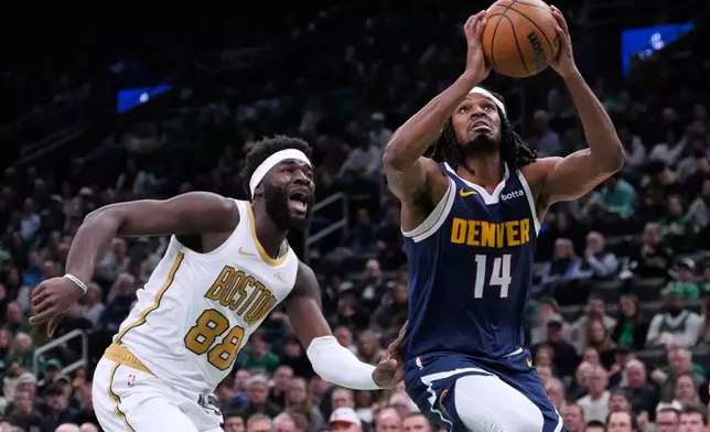 Denver Nuggets forward Daron Holmes II (14) drives to the basket past Boston Celtics center Neemias Queta (88) during the first half of an NBA basketball game, Wednesday, Jan. 7, 2026, in Boston. (AP Photo/Charles Krupa)