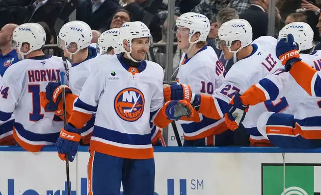 New York Islanders' Carson Soucy (4) celebrates with teammates after scoring a goal during the second period of an NHL hockey game against the New York Rangers Thursday, Jan. 29, 2026, in New York. (AP Photo/Frank Franklin II)