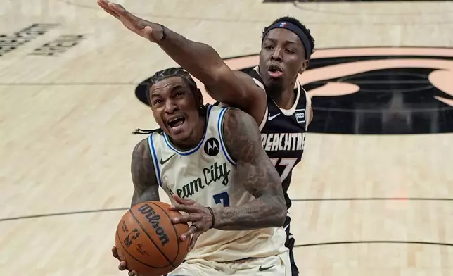 Milwaukee Bucks guard Kevin Porter Jr. (7) drives against Atlanta Hawks forward Onyeka Okongwu (17) during the second half of an NBA basketball game, Monday, Jan. 19, 2026, in Atlanta. (AP Photo/Mike Stewart)