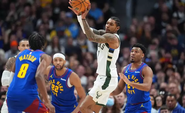 Milwaukee Bucks guard Kevin Porter Jr., third from left, passes the ball as Denver Nuggets guard Peyton Watson, left, center Zeke Nnaji and guard Jalen Pickett defend in the second half of an NBA basketball game, Sunday, Jan. 11, 2026, in Denver. (AP Photo/David Zalubowski)