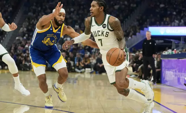 Milwaukee Bucks forward Kevin Porter Jr. (7) drives to the basket against Golden State Warriors guard Moses Moody (4) during the first half of an NBA basketball game in San Francisco, Wednesday, Jan. 7, 2026. (AP Photo/Jeff Chiu)