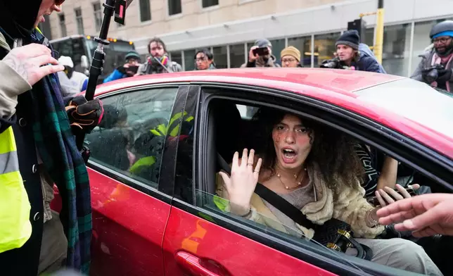 Jake Lang, who organized the protest March Against Minnesota Fraud, leaves the rally by getting into a car near Minneapolis City Hall, Saturday, Jan. 17, 2026, in Minneapolis. (AP Photo/Yuki Iwamura)