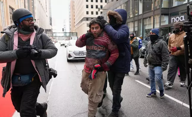 A person tries to forcibly remove a Jake Lang’s supporter’s sweatshirt during an altercation at the March Against Minnesota Fraud rally near Minneapolis City Hall, Saturday, Jan. 17, 2026, in Minneapolis. (AP Photo/Yuki Iwamura)