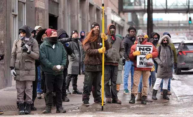 Pro-immigration protesters stand on the sideway Saturday, Jan. 17, 2026, in Minneapolis. (AP Photo/Yuki Iwamura)