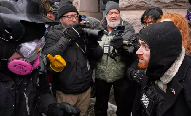 A pro-immigration protester, left, clashes with a man attending the March Against Minnesota Fraud, right, in front of Minneapolis City Hall, Saturday, Jan. 17, 2026, in Minneapolis. (AP Photo/Yuki Iwamura)