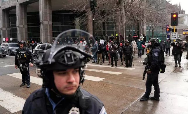 Minneapolis Police officers secure the intersection where protesters are gathered Saturday, Jan. 17, 2026, in Minneapolis. (AP Photo/Yuki Iwamura)