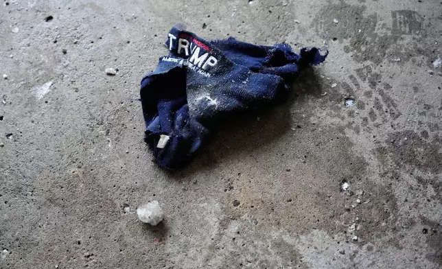 A ripped Trump hat lies on the ground of a parking garage Saturday, Jan. 17, 2026, in Minneapolis. (AP Photo/Yuki Iwamura)