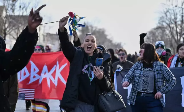 People protest as law enforcement officers attend to the scene of the shooting involving federal law enforcement agents, Wednesday, Jan. 7, 2026, in Minneapolis. (AP Photo/Tom Baker)