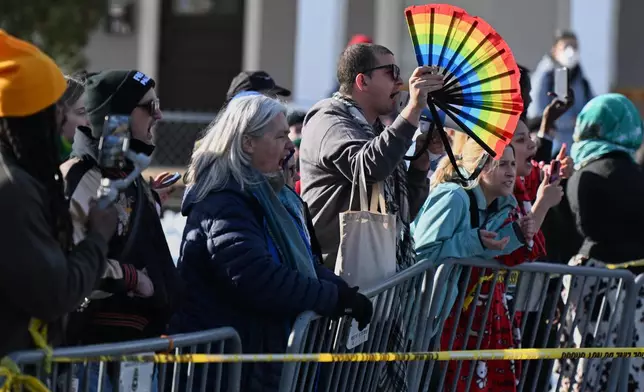 People protest as law enforcement officers attend to the scene of the shooting involving federal law enforcement agents, Wednesday, Jan. 7, 2026, in Minneapolis. (AP Photo/Tom Baker)