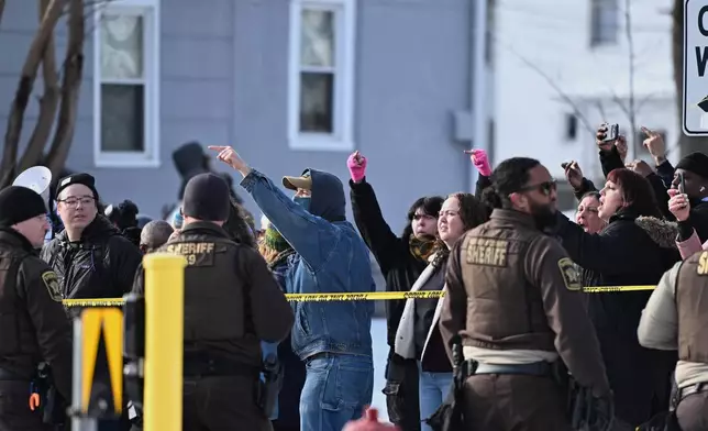 EDS NOTE: OBSCENITY - People protest as law enforcement officers attend to the scene of the shooting involving federal law enforcement agents, Wednesday, Jan. 7, 2026, in Minneapolis. (AP Photo/Tom Baker)