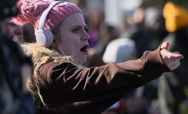 People protest as law enforcement officers attend to the scene of the shooting involving federal law enforcement agents, Wednesday, Jan. 7, 2026, in Minneapolis. (AP Photo/Tom Baker)