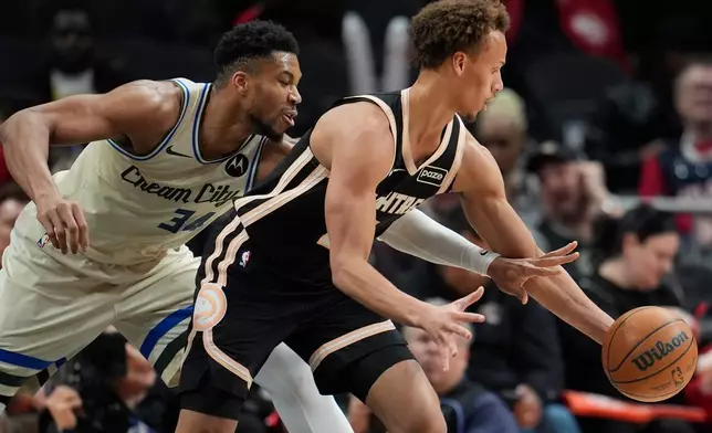 Atlanta Hawks guard Dyson Daniels (5) moves the ball against Milwaukee Bucks forward Giannis Antetokounmpo (34) during the first half of an NBA basketball game, Monday, Jan. 19, 2026, in Atlanta. (AP Photo/Mike Stewart)