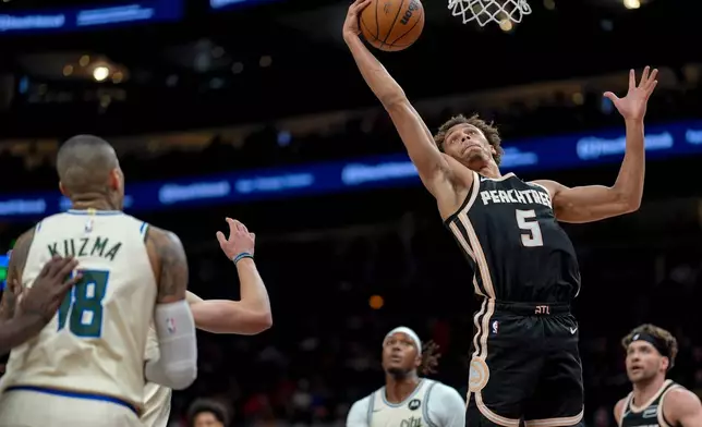 Atlanta Hawks guard Dyson Daniels (5) shoots against the Milwaukee Bucks during the first half of an NBA basketball game, Monday, Jan. 19, 2026, in Atlanta. (AP Photo/Mike Stewart)