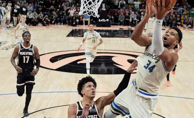 Milwaukee Bucks forward Giannis Antetokounmpo (34) shoots against Atlanta Hawks forward Jalen Johnson (1) during the second half of an NBA basketball game, Monday, Jan. 19, 2026, in Atlanta. (AP Photo/Mike Stewart)