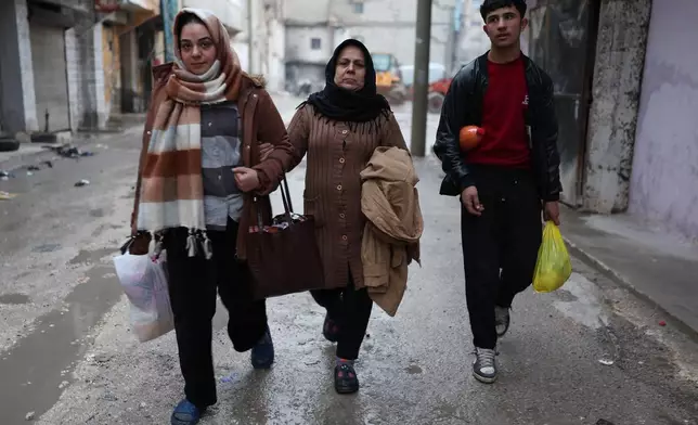 People flee the Sheikh Maqsoud neighborhood, where clashes between government forces and Kurdish fighters have been taking place in the northern city of Aleppo, Syria, Sunday, Jan. 11, 2026. (AP Photo/Ghaith Alsayed)