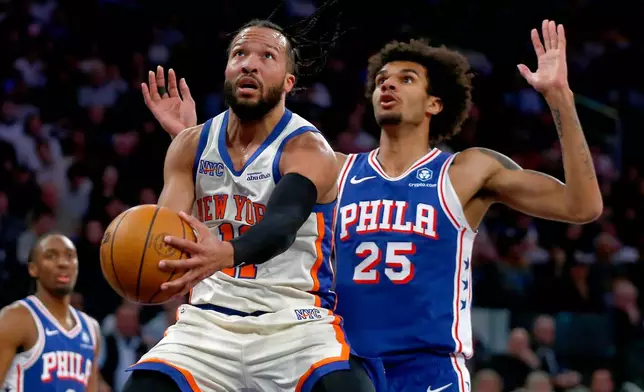 New York Knicks guard Jalen Brunson, left, drives to the basket last Philadelphia 76ers forward Dominick Barlow, right, during the first half of an NBA basketball game, Saturday, Jan. 3, 2026, in New York. (AP Photo/John Munson)
