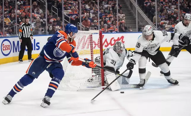 Los Angeles Kings goalie Anton Forsberg (31) makes a save on Edmonton Oilers' Leon Draisaitl (29) as Alex Turcotte (15) defends during the second period of an NHL game, in Edmonton, Alberta, Saturday, Jan. 10, 2026. (Jason Franson/The Canadian Press via AP)
