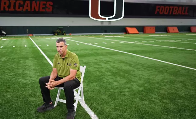 Miami football head coach Mario Cristobal sits on the team's indoor practice field during an interview in Coral Gables, Fla., Monday, Jan. 12, 2026. (AP Photo/Rebecca Blackwell)