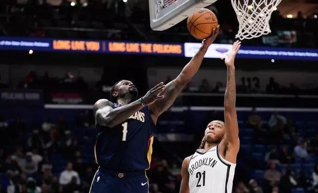 New Orleans Pelicans forward Zion Williamson (1) goes to the basket against Brooklyn Nets forward Noah Clowney (21) in the first half of an NBA basketball game, Wednesday, Jan. 14, 2026, in New Orleans. (AP Photo/Gerald Herbert)