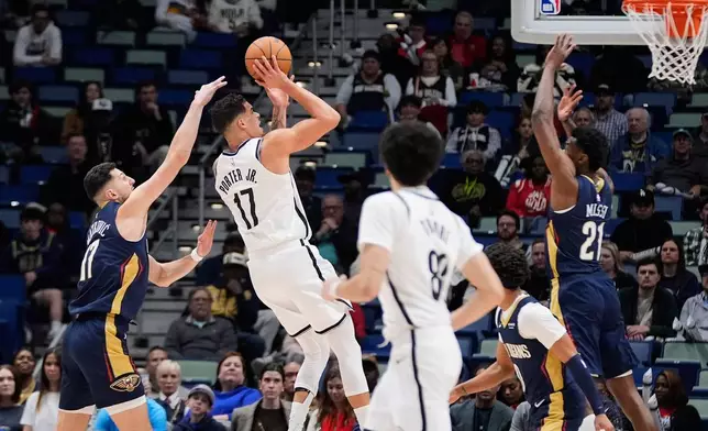 Brooklyn Nets forward Michael Porter Jr. (17) shoots between New Orleans Pelicans center Yves Missi (21) and forward Karlo Matkovic (17) in the first half of an NBA basketball game, Wednesday, Jan. 14, 2026, in New Orleans. (AP Photo/Gerald Herbert)
