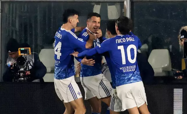 Como's Marc-Oliver Kempf, center, celebrates scoring during the Serie A soccer match between Como and Milan in Como, Italy, Thursday Jan. 15, 2026. (Antonio Saia/LaPresse via AP)