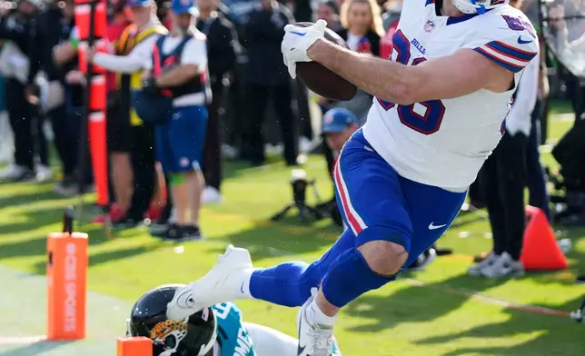 Buffalo Bills tight end Dalton Kincaid (86) scores a touchdown in front of Jacksonville Jaguars cornerback Greg Newsome II (6) during the second half of an NFL wild-card playoff football game Sunday, Jan. 11, 2026, in Jacksonville, Fla. (AP Photo/John Raoux)