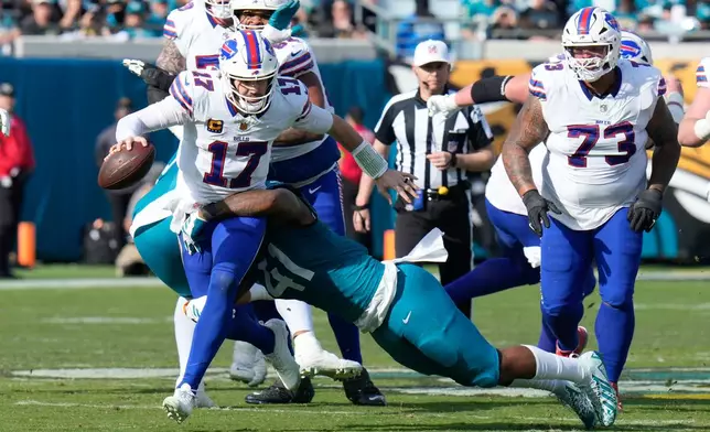 Buffalo Bills quarterback Josh Allen (17) is tackled by Jacksonville Jaguars defensive end Josh Hines-Allen (41) during the second half of an NFL wild-card playoff football game Sunday, Jan. 11, 2026, in Jacksonville, Fla. (AP Photo/Chris O'Meara)