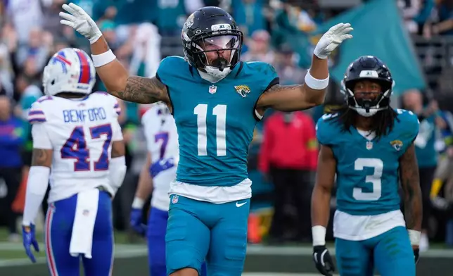 Jacksonville Jaguars wide receiver Parker Washington (11) celebrates after scoring a touchdown against the Buffalo Bills during the second half of an NFL wild-card playoff football game Sunday, Jan. 11, 2026, in Jacksonville, Fla. (AP Photo/John Raoux)
